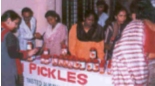 Photograph of women selling jars of pickle